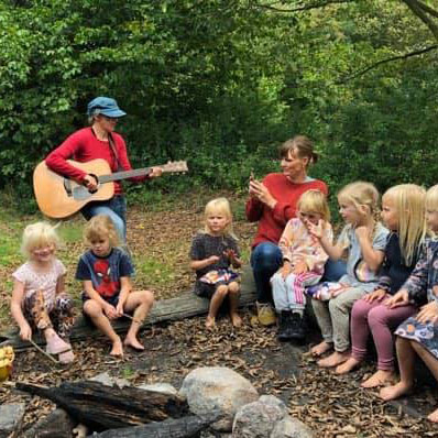 Mette spiller guitar med børn